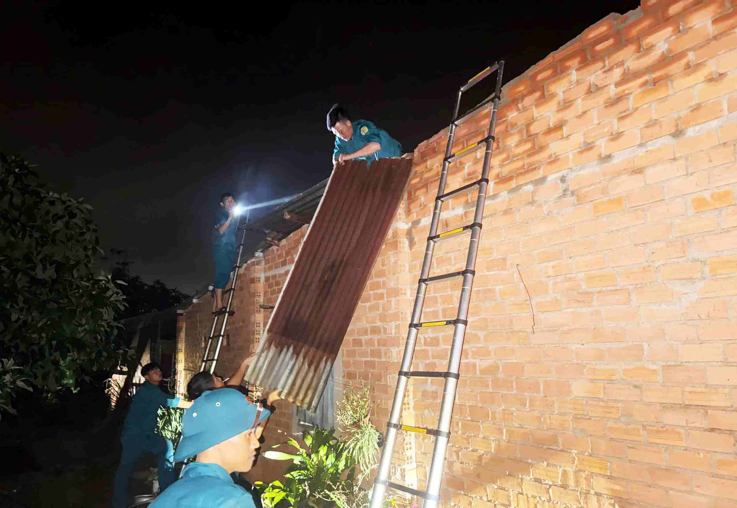 바오록 1구역 병력이 밤에 주민들이 지붕을 다시 덮는 것을 돕고 있습니다. 사진: 푹카잉