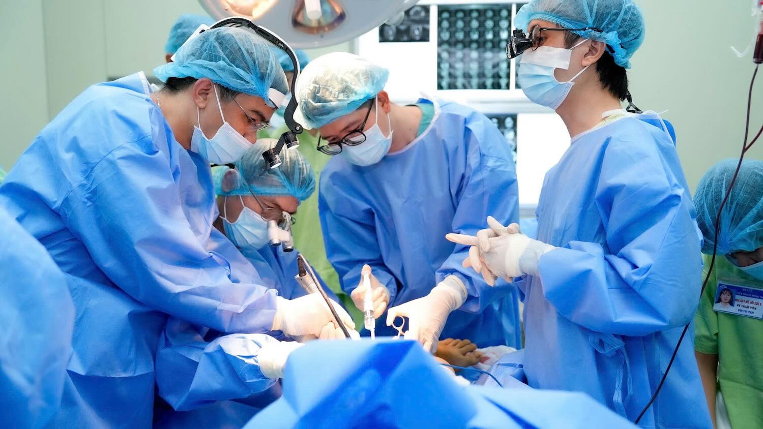 Doctors performing the surgery. Photo: Nhat Tan.