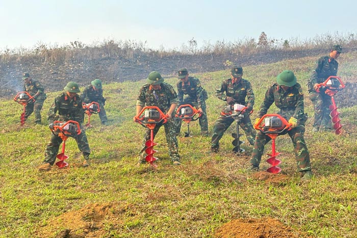 Cadres and soldiers of Regiment 741 - Dien Bien Provincial Military Command help people in Muong Cha commune dig holes to plant macadamia and coffee. Photo: Duc Hanh