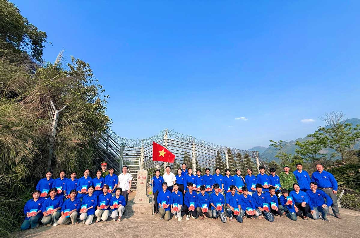 31 đoàn viên mới chụp ảnh lưu niệm tại cột mốc 166 – dấu mốc thiêng liêng của Tổ quốc.