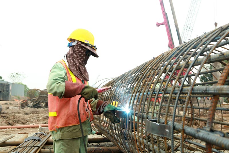 Workers making steel cages to serve the construction of drilled piles for the foundation of Tran Hung Dao bridge. Photo: Huu Chanh