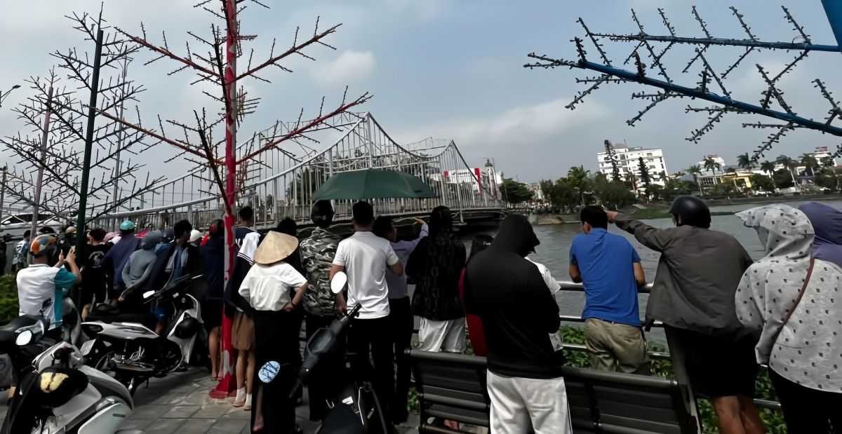 People watch the search process for the young man suspected of jumping off the bridge. Photo: People provided