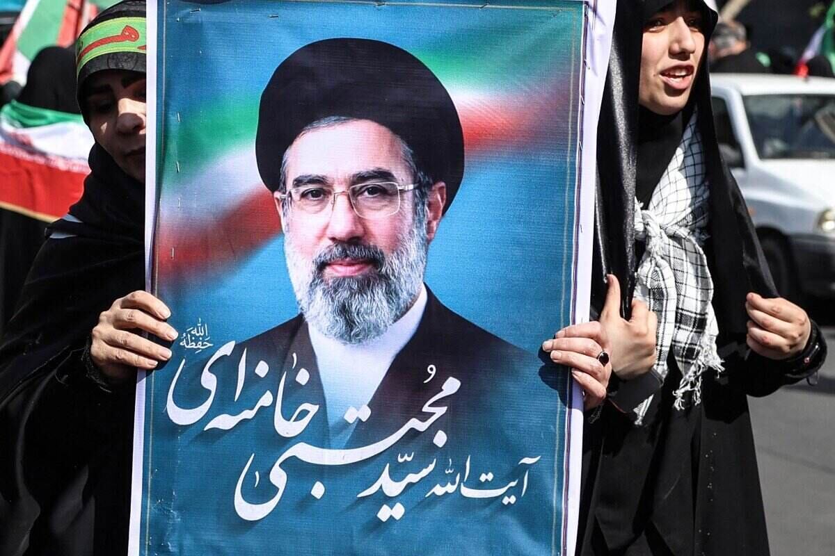 An Iranian woman raises the image of Iran's Supreme Leader Mojtaba Khamenei. Photo: AFP