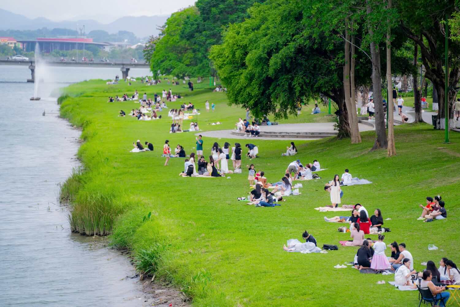 People and tourists stroll and enjoy the poetic Perfume River. Photo: Le Dinh Hoang.