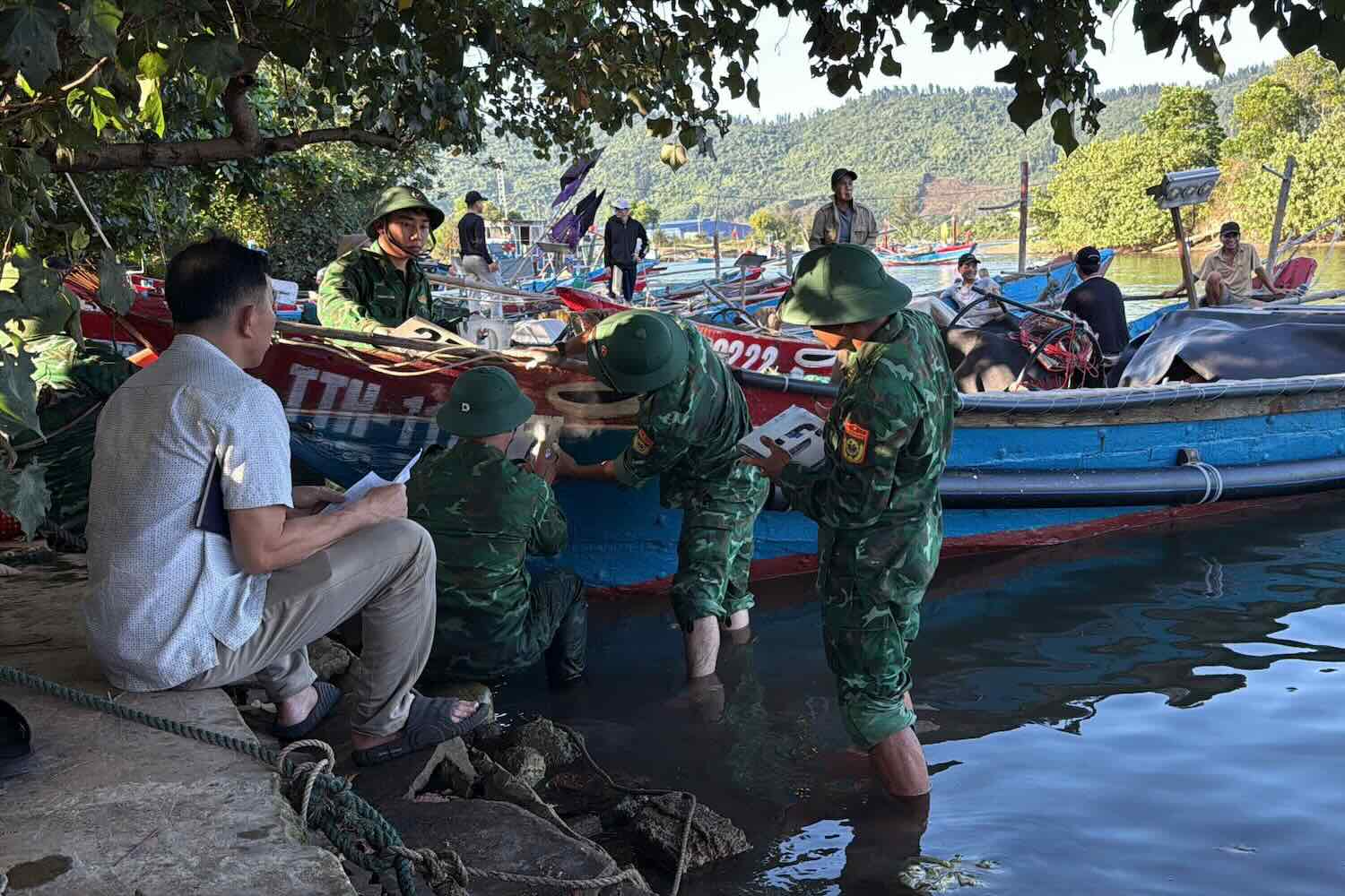 Border Guards of Chan May Port Border Guard Station support fishermen to paint ship numbers. Photo: Vo Tien.
