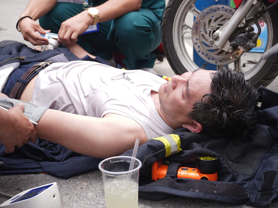 Firefighters exhausted after many hours of fighting the fire at a karaoke bar in Hanoi