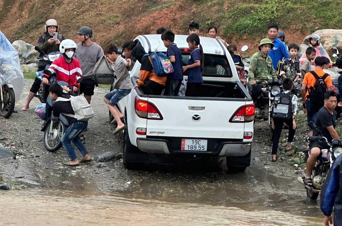 Anh Trần Văn Mạnh dùng xe bán tải hỗ trợ đưa đón học sinh qua vùng ngập nguy hiểm. Ảnh: Công an xã Trịnh Tường