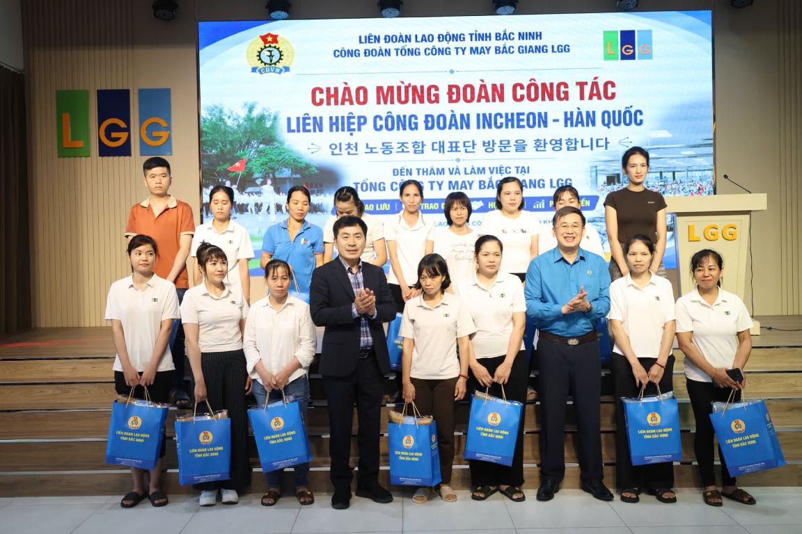 Thạch Văn Chung và ông Ko Gi Su tặng quà công nhân hoàn cảnh khó khăn Công ty Cổ phần Tổng Công ty May Bắc Giang LGG. Ảnh: Quyết Chiến  