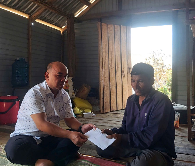 Vice Chairman of the Provincial Vietnam Fatherland Front Committee (left cover) presents gifts to support and encourage Mr. Mut after the stilt house fire. Photo: Mai Chi