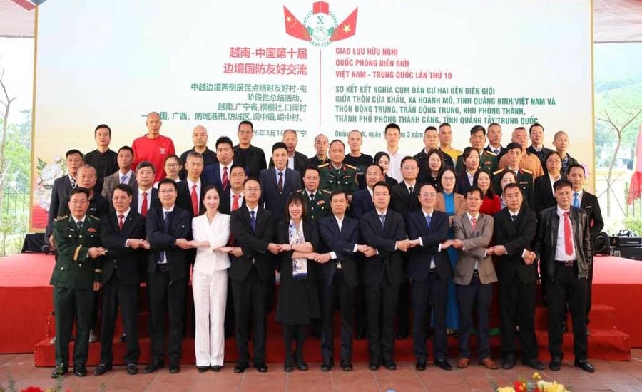 Authorities and people of both sides take souvenir photos at the 10th anniversary of the twinning ceremony of residential clusters on both sides of the border between Cua Khau village, Hoanh Mo commune, Quang Ninh province, Vietnam and Dong Trung village, Dong Trung town, Phong Thanh area, Phong Thanh City, Guangxi, China on March 16, 2026. Photo: Minh Duc
