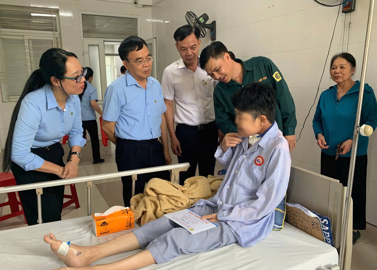Chủ tịch Công đoàn Công ty Tuyển than Cửa Ông thăm hỏi công nhân đang điều trị tại bệnh viện. Ảnh: Đoàn Hưng