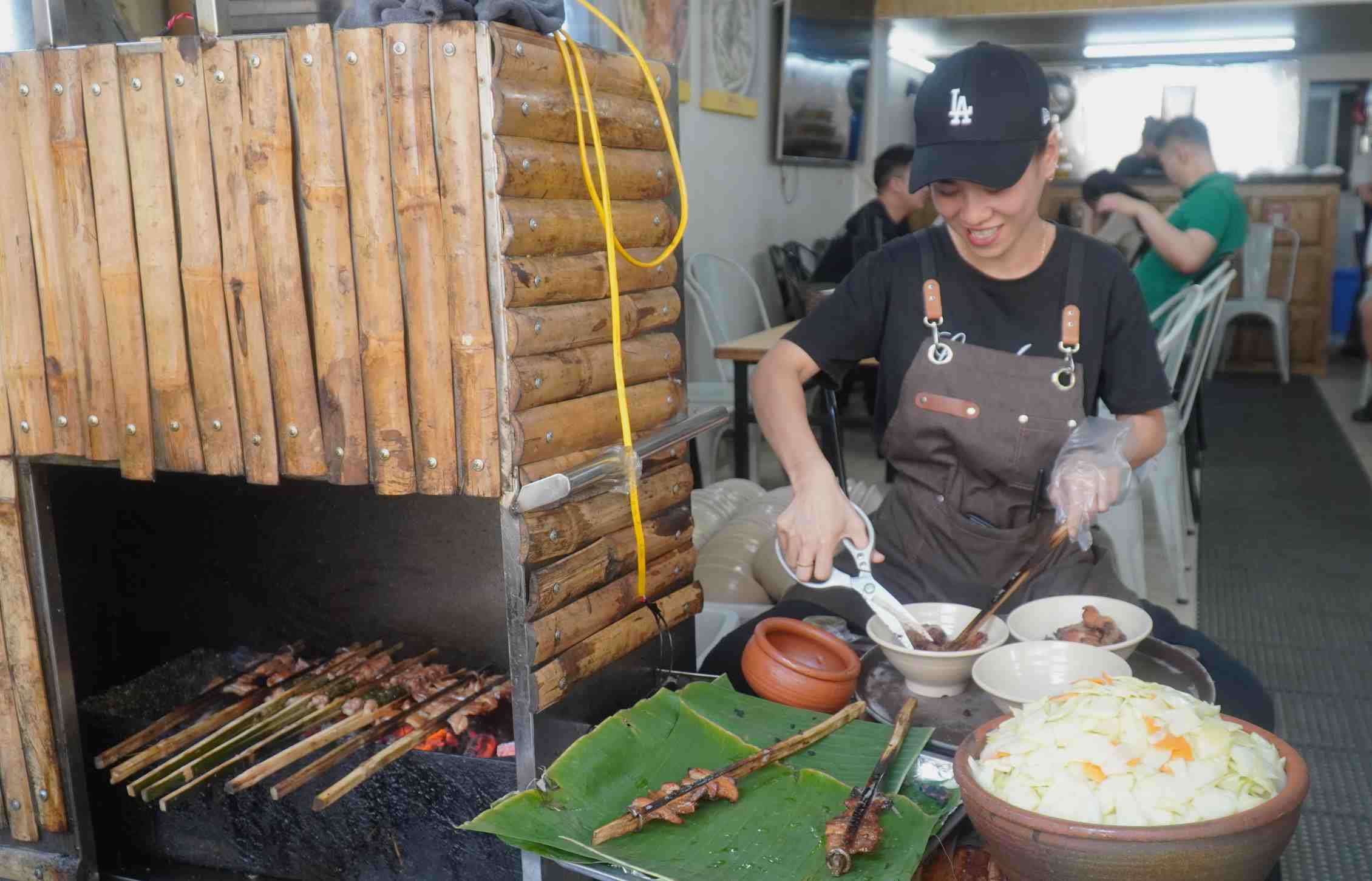 Từng xiên chả nướng trên que tre dậy mùi hấp dẫn được nhân viên cắt ra miếng vừa ăn. Ảnh: Minh Vũ