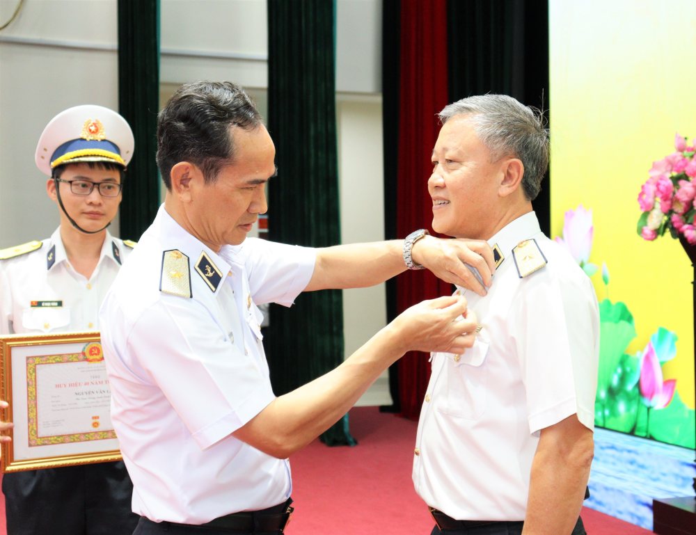 Rear Admiral Nguyen Huu Thoan - Secretary of the Party Committee, Political Commissar of the Naval Academy - awarded the 40-year Party Badge to Rear Admiral Nguyen Van Lam - former Director of the Academy. Photo: Dinh Tien