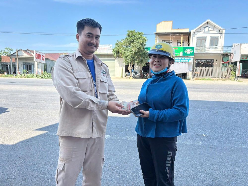 Picking up dropped money, union members of MAG Quang Tri Project find the person to return it. Photo: Quang Tri Trade Union