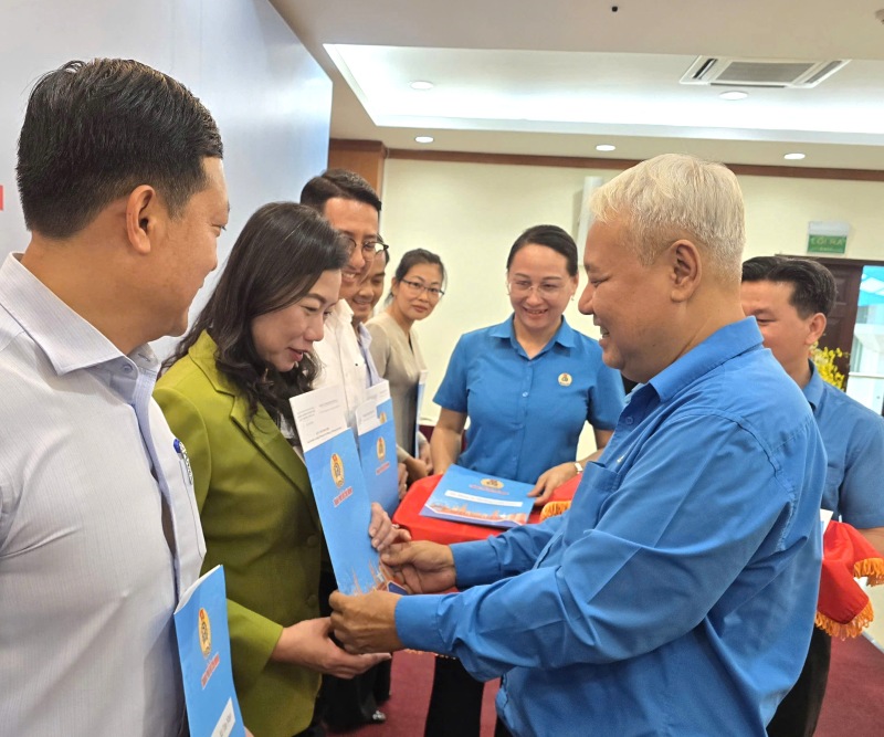 Ông Võ Khắc Thái - Phó Chủ tịch Thường trực LĐLĐ TPHCM - trao quy chế phối hợp với lãnh đão một số Đảng ủy các phường, xã, đặc khu trên địa bàn TPHCM. Ảnh: Nam Dương