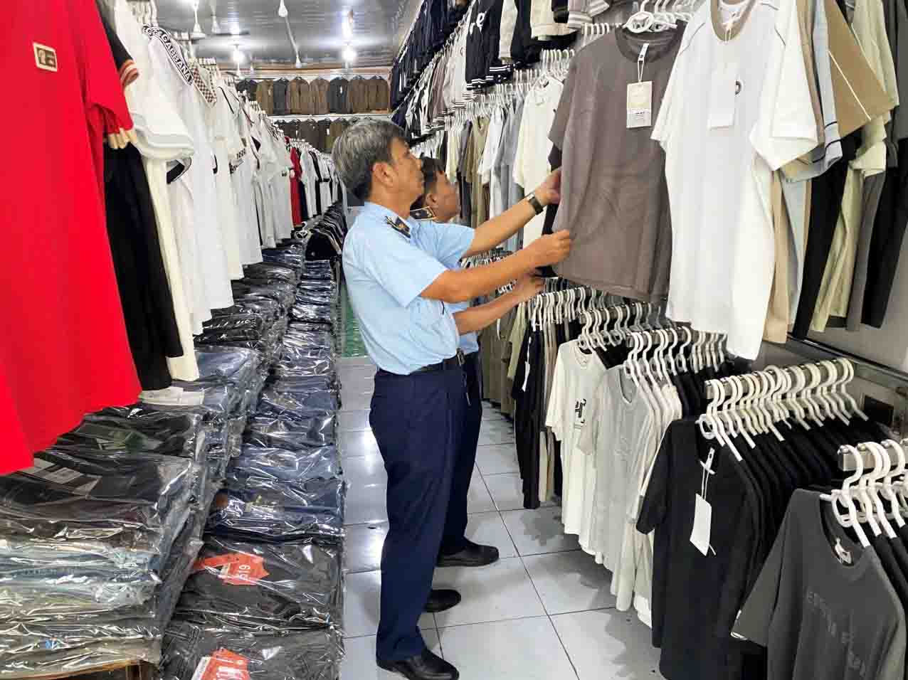 Đoàn kiểm tra Đội Quản lý thị trường số 18 kiểm tra tại một hộ kinh doanh quần áo.