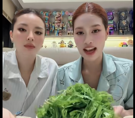 Hoa hậu Kỳ Duyên và Thiên Ân thưởng thức hẹ nước chấm mắm kho. Ảnh: Cắt từ video.