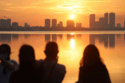 Los jóvenes de Hanoi se apresuran a cazar la puesta de sol roja brillante junto al lago Ho Tay