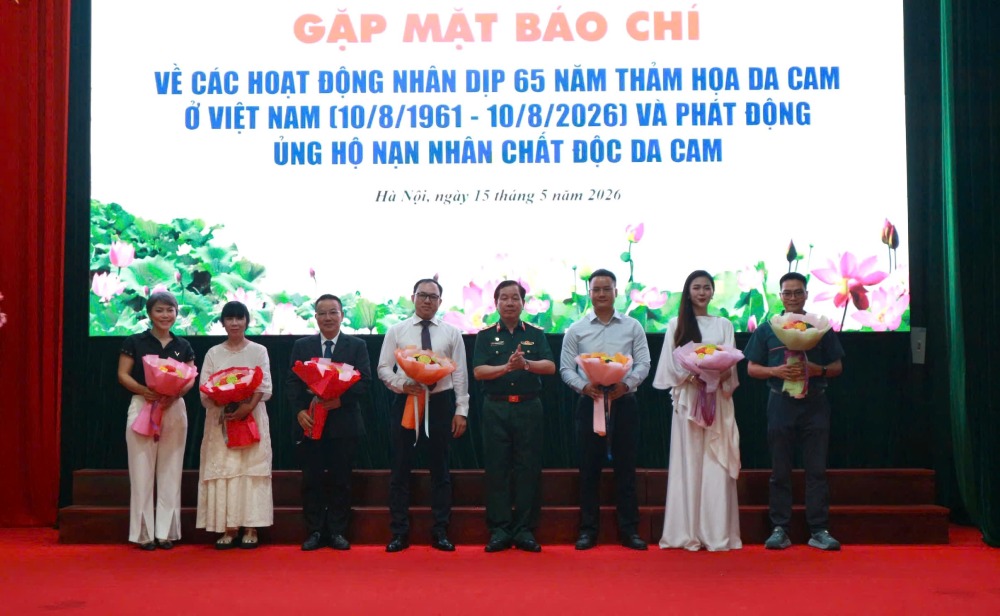 Lieutenant General Nguyen Huu Chinh - Chairman of the Vietnam Association of Agent Orange/dioxin Victims presents flowers to thank sponsors for supporting the Vietnam Agent Orange Victims Fund. Photo: Quynh Chi