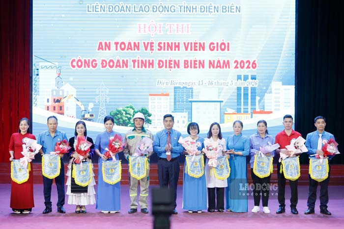 Leaders of Dien Bien Provincial Labor Federation present flowers and souvenir flags to the contestants. Photo: Quang Dat