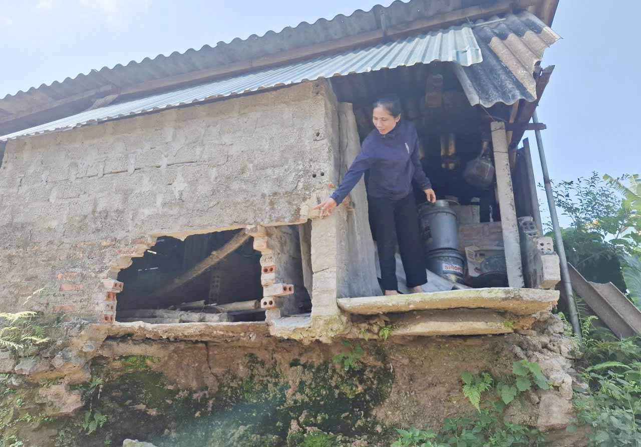 Ms. Thin next to the kitchen area that was damaged by landslides. Photo: Tran Tuan