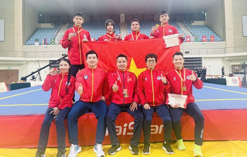 La combattante Thu Thủy (à l'extrême droite, rangée inférieure) et l'équipe vietnamienne de wushu à la Coupe du monde de tán thủ 2026. Photo: Vũ Văn