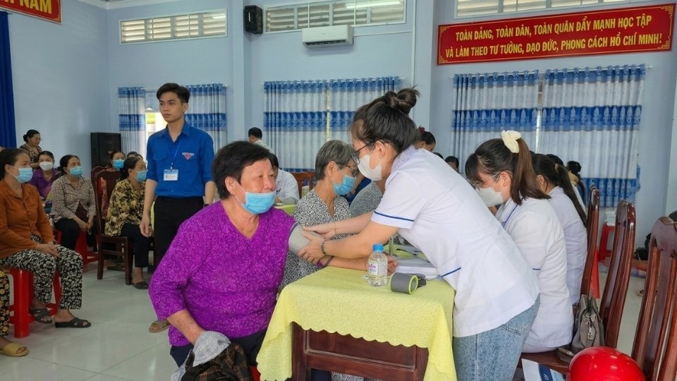 People in Truong Long Hoa ward are given free health check-ups and health care advice by doctors. Photo: Hoang Loc