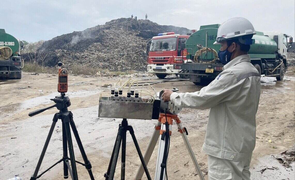 The Geodetic and Environmental Monitoring Center (under the Quang Ngai Department of Agriculture and Environment) takes monitoring samples at the garbage pit area where the fire just occurred. Photo: Y Thu