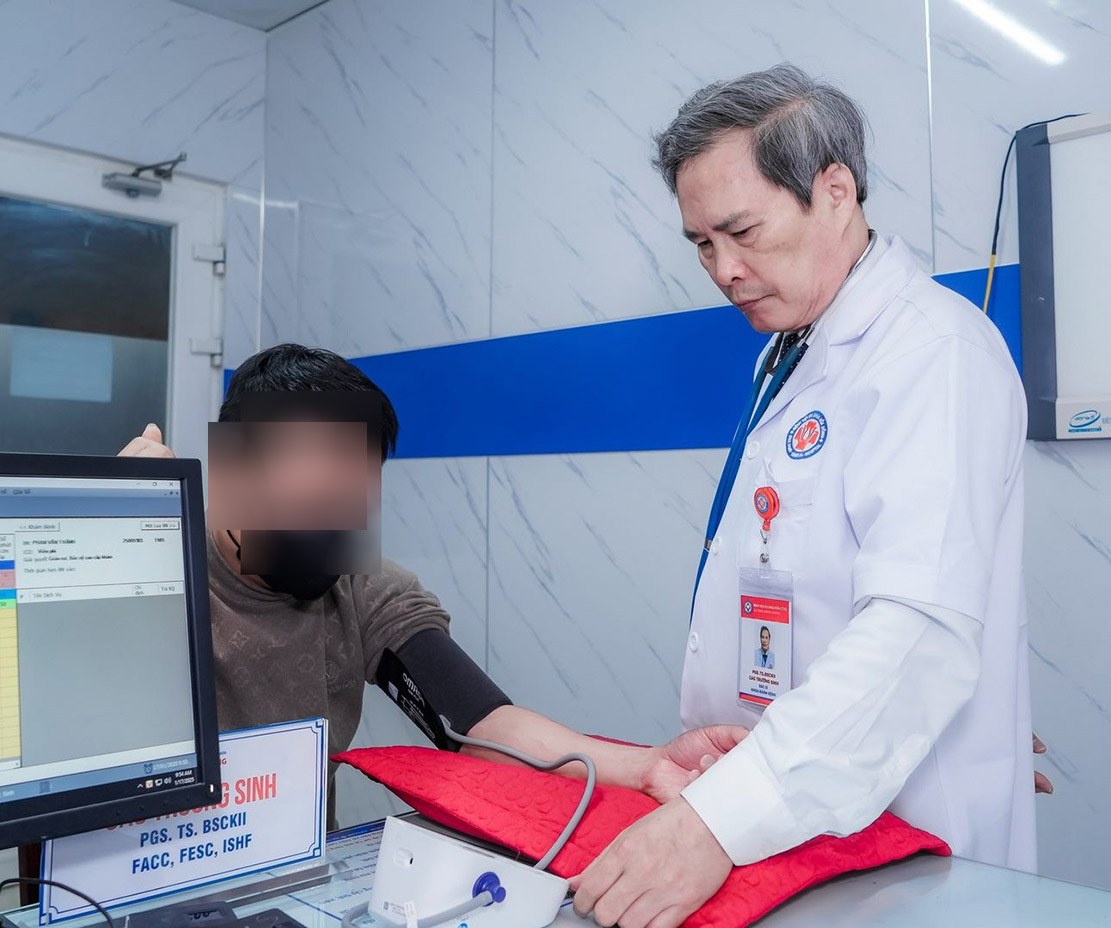 PGS.TS.BSCKII Cao Trường Sinh - nguyên Phó Hiệu trưởng Trường Đại học Y khoa Vinh, nguyên Giám đốc Bệnh viện Trường Đại học Y khoa Vinh - kiểm tra huyết áp cho bệnh nhân. Ảnh: Ngọc Anh