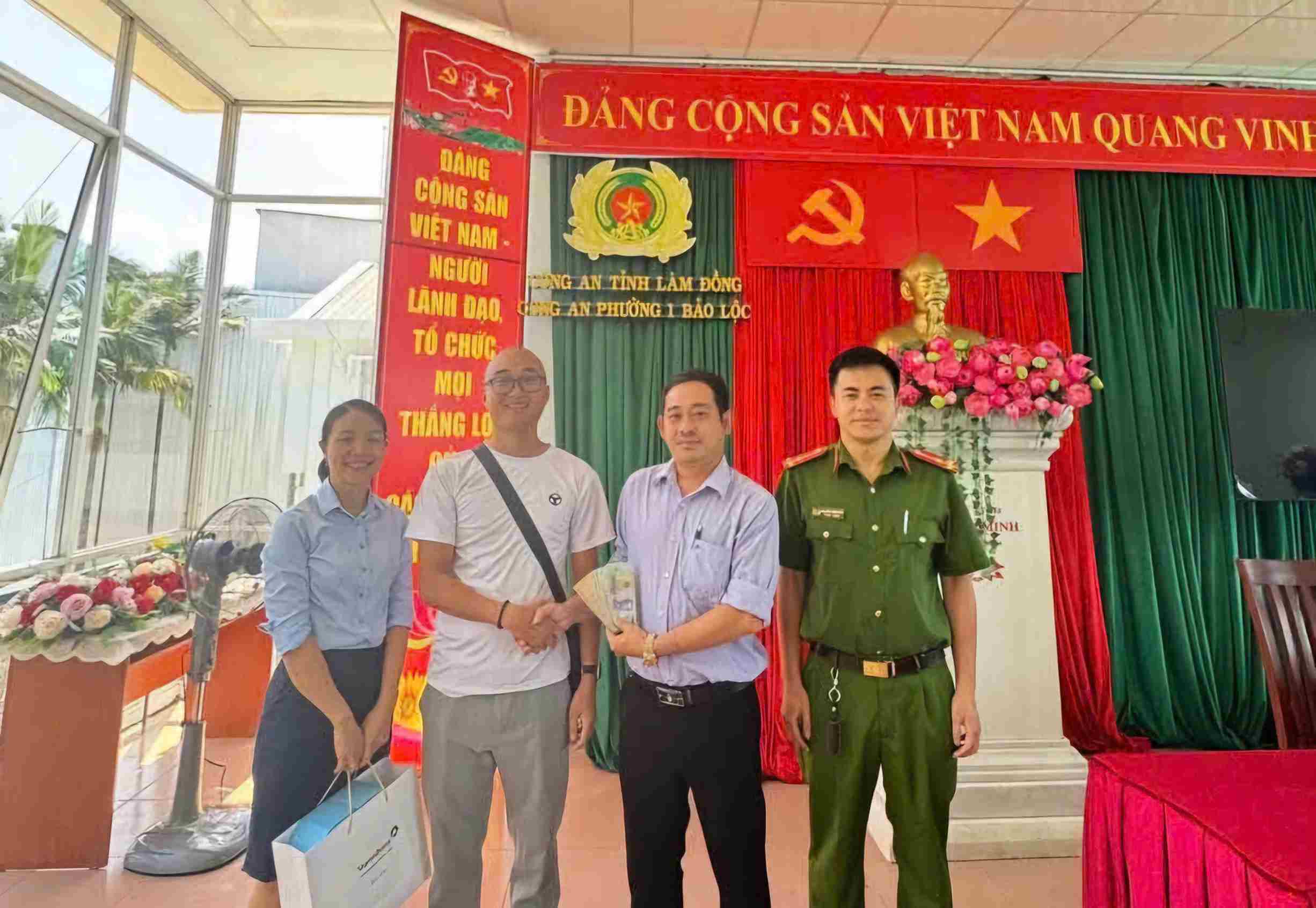 Mr. Nguyen Thanh Hung (2nd from right) coordinates with the police to return the collected money to Mr. Nguyen Tien Loi. Photo: Than Hy
