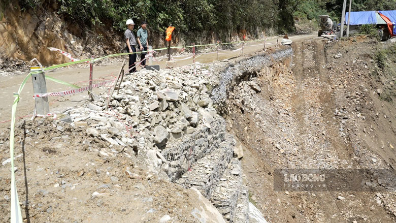 Workers stick to the road amidst floods to maintain traffic flow in the highlands. Photo: Hung Cuong