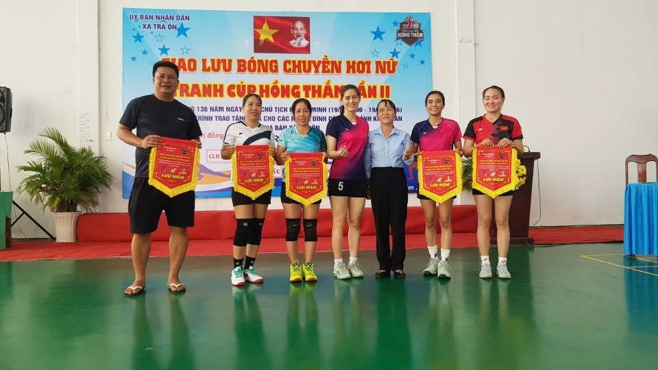 Representatives of the teams receive souvenir flags from the Organizing Committee before entering the women's draft volleyball friendly competition. Photo: Hoang Loc