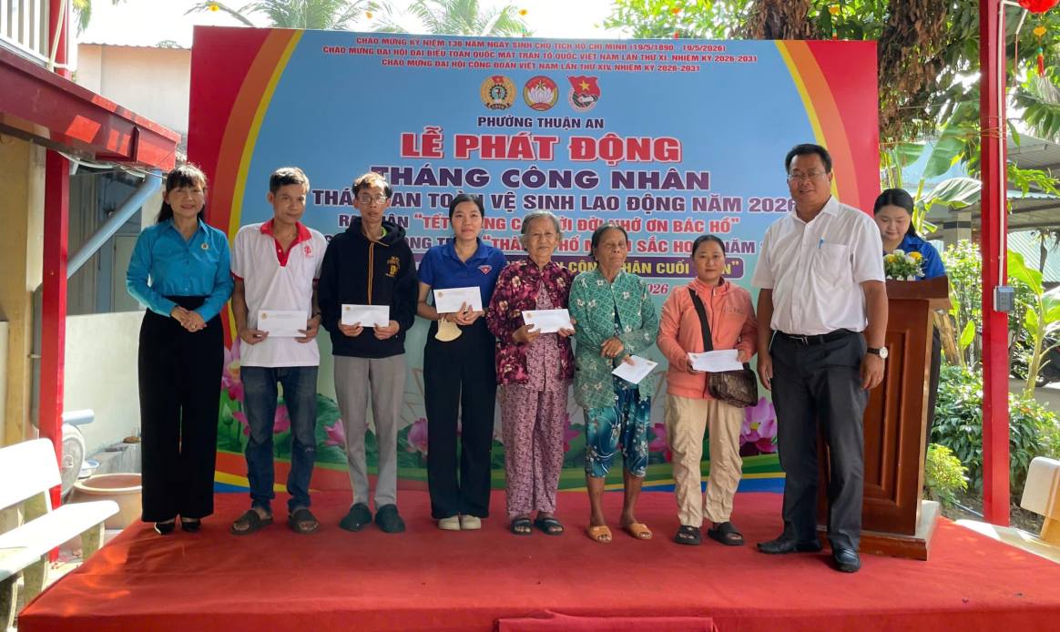 Bà Đặng Thị Kim Chi - Tổ phó Tổ Công tác Quản lý địa bàn số 4 LĐLĐ TPHCM và ông Nguyễn Thanh Sơn - Chủ tịch UBND phường Thuận An trao quà cho công nhân lao động khó khăn. Ảnh: Đình Trọng