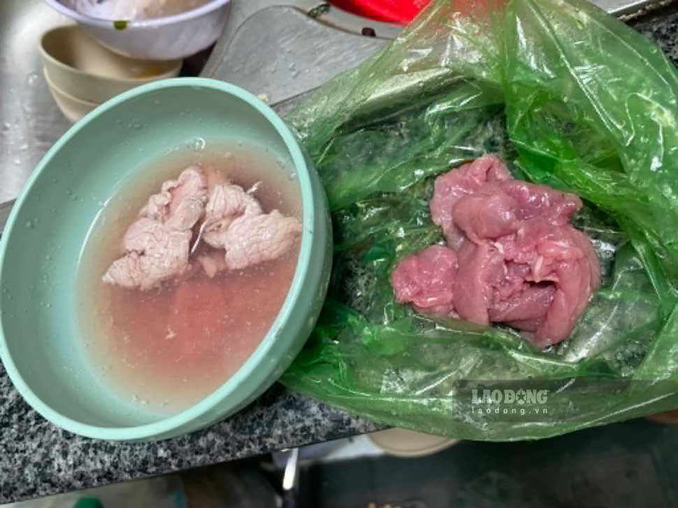 Vợ chồng anh N. mang phần thịt bò nghi làm giả đến phản ánh với chủ quầy bán thịt. Ảnh: H.N.