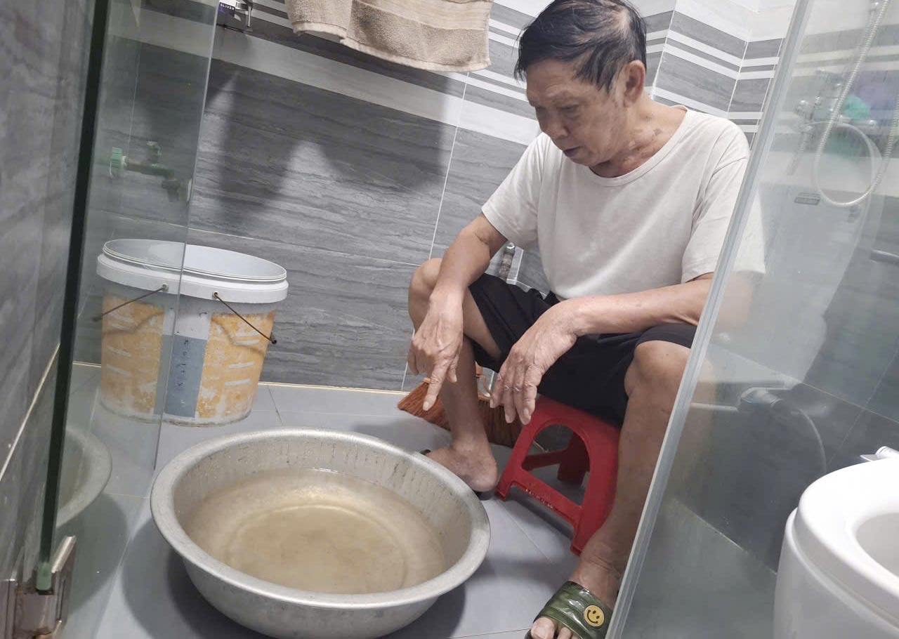 Mr. Cuong next to a basin of clean water with a cloudy yellow color, not guaranteed quality. Photo: Tran Tuan