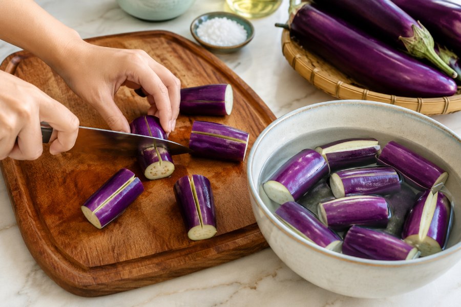 Cà tím được cắt khúc và bổ nhẹ ở giữa để chuẩn bị nhồi thịt. Ảnh: Thùy Linh