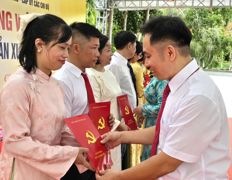 Representatives of the Party cell present the Party admission decision to party members. Photo: Nam Duong