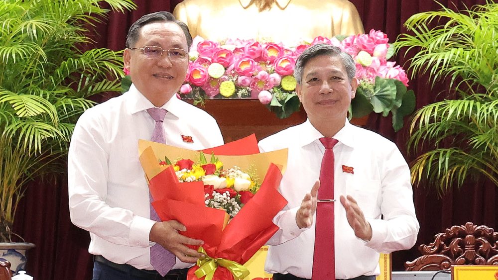 Phó Bí thư Thường trực Thành ủy và Chủ tịch UBND TP trao quyết định, tặng hoa chúc mừng ông Lê Công Lý.
