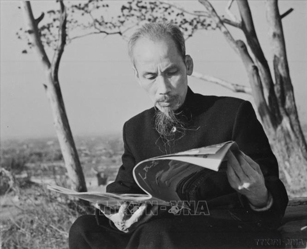 Le président Hô Chi Minh lit le journal devant sa maison d'hôtes lors d'une visite en Chine, en 1953. Photo: TTXVN
