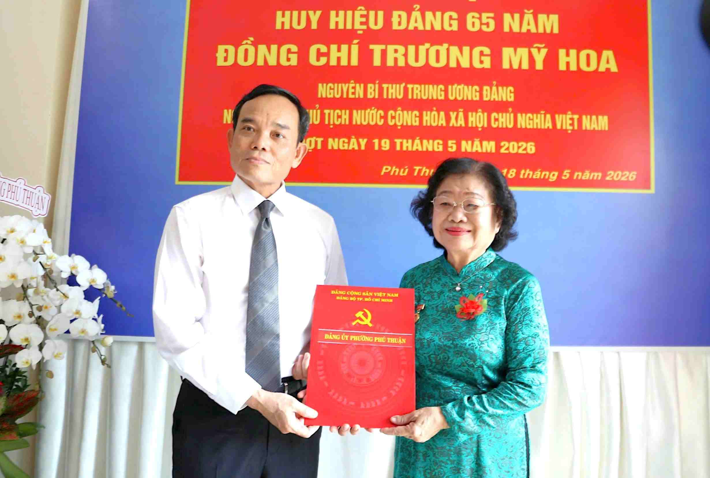 Secretary of the Ho Chi Minh City Party Committee Tran Luu Quang awarded the 65-year Party Badge to former Vice President Truong My Hoa. Photo: Tran Hien
