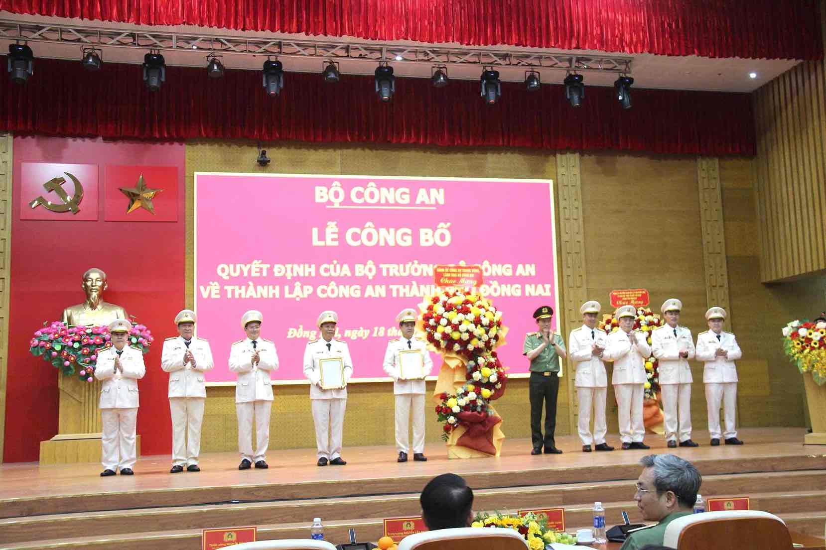 Le général Luong Tam Quang, membre du Bureau politique, secrétaire du Comité du Parti de la police centrale, ministre de la Sécurité publique, a remis la décision et offert des fleurs pour féliciter le conseil d'administration de la police de la ville de Dong Nai. Photo: HAC