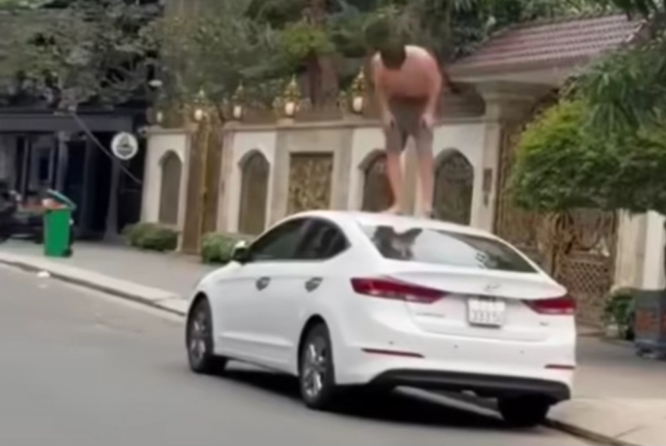 Foreign tourists shirtless, climbing car roofs to smash things, causing chaos in Da Nang's Western Quarter. Photo: Truong An