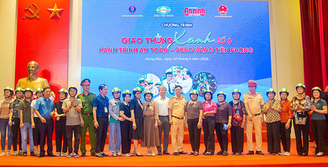 Đại diện Công an, lãnh đạo phường và Công ty Nhựa Tiền Phong tặng mũ bảo hiểm cho người dân. Ảnh: Minh Châu