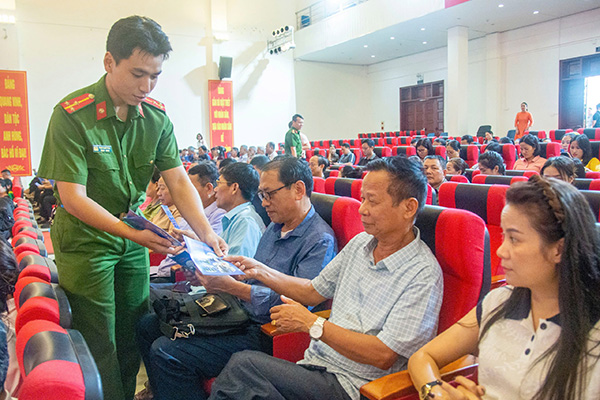 Tặng tài liệu về an toàn giao thông cho người dân. Ảnh: Minh Châu