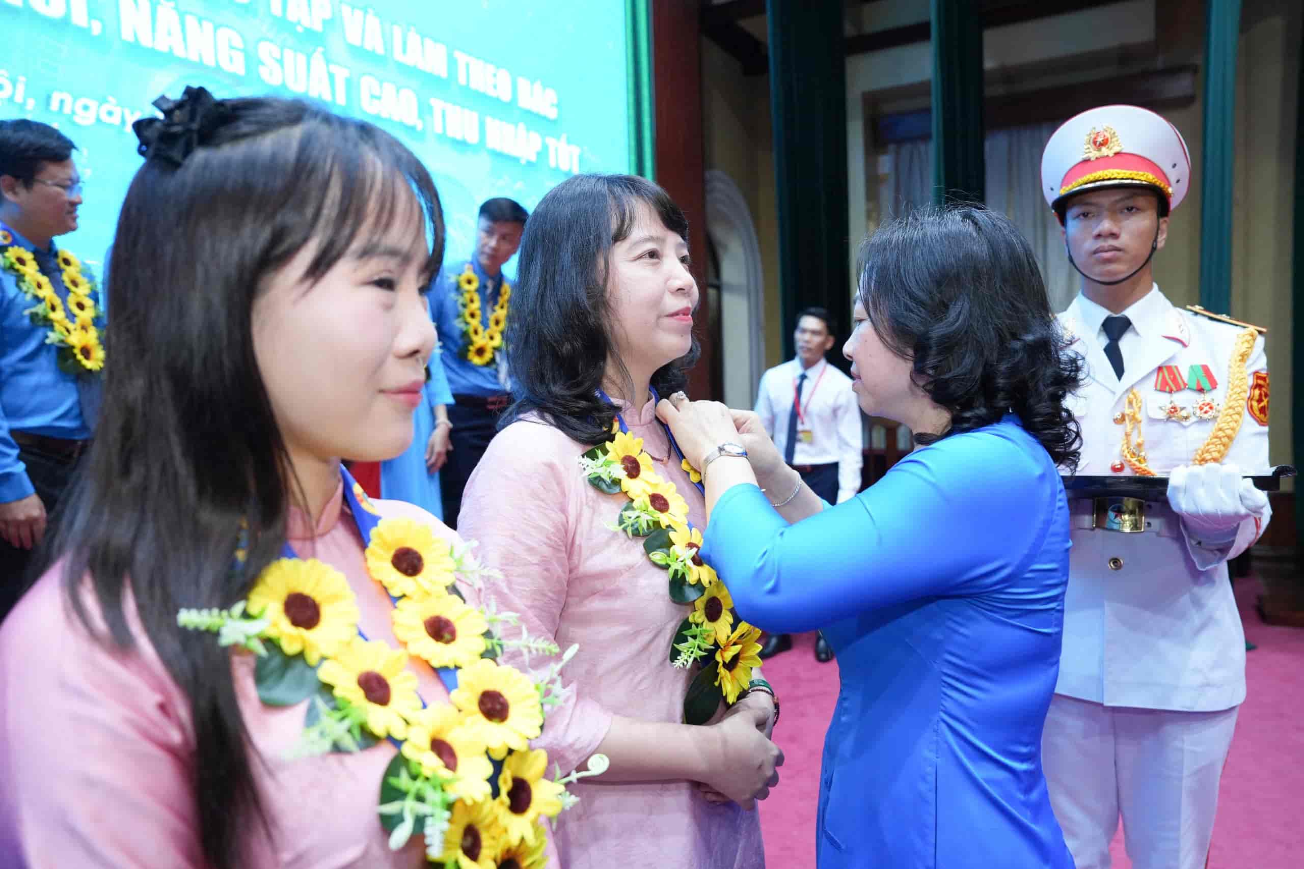 Bà Thái Thu Xương trao huy hiệu Bác Hồ cho đại biểu được biểu dương. Ảnh: Hữu Chánh.