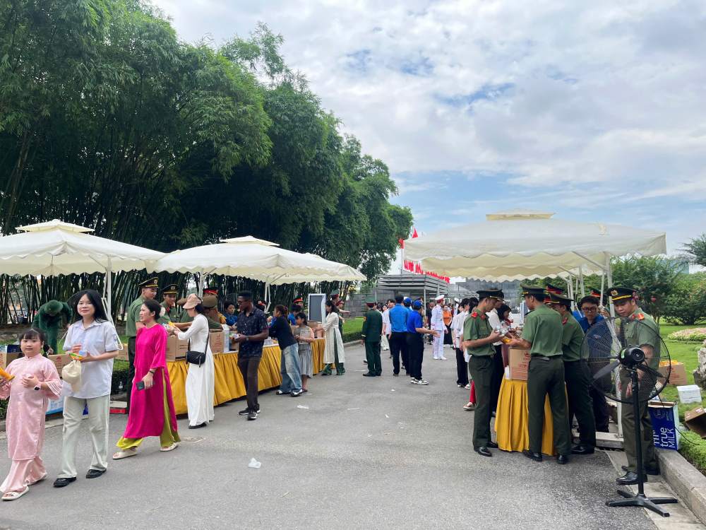 Người dân nhận những suất quà gồm đồ ăn, nước uống miễn phí sau khi vào thăm Lăng Bác. Ảnh: Chí Long