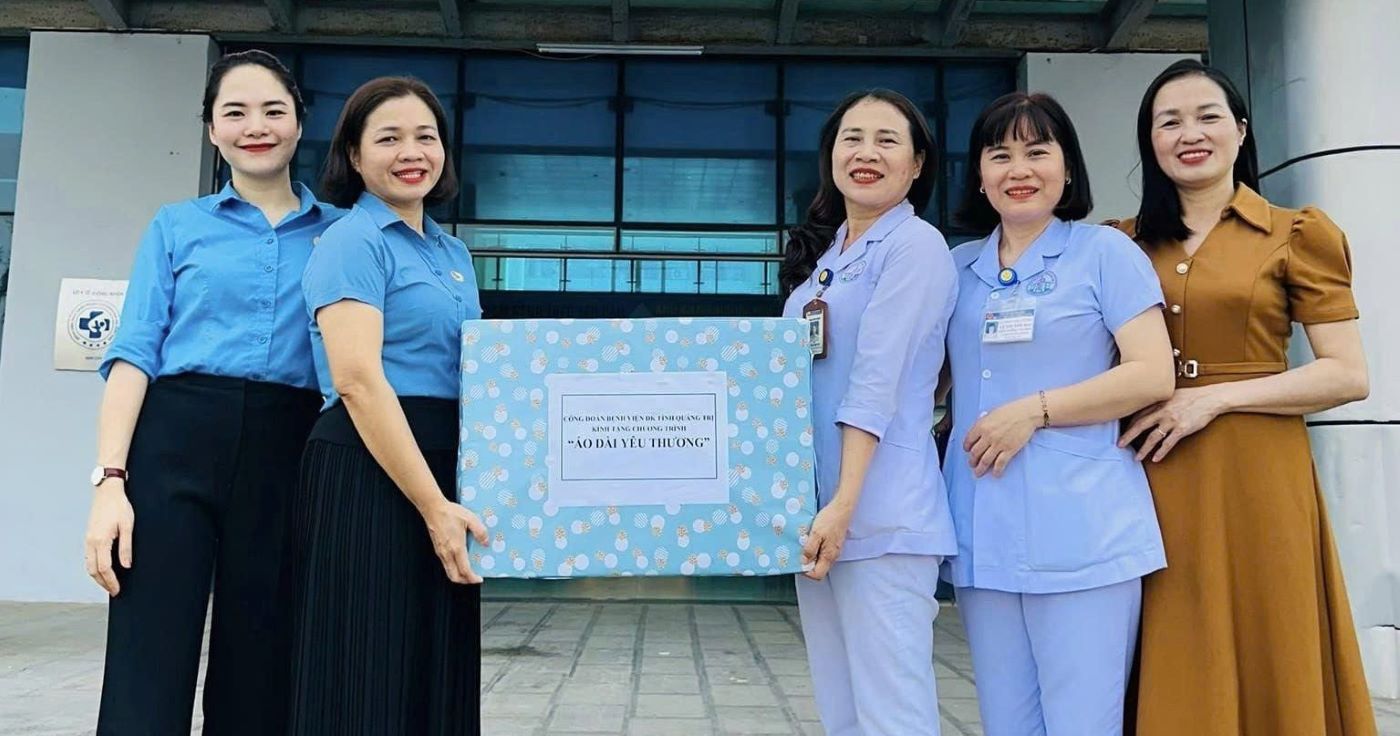 Nurse Thuy My (3rd from right) and colleagues present ao dai in support of female workers. Photo: Han Nguyen