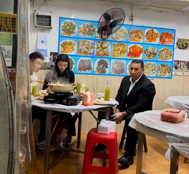 Hề Mộng Dao - Hà Du Quân ngồi ăn cùng vệ sĩ ở quán bình dân. Ảnh: Xinhua