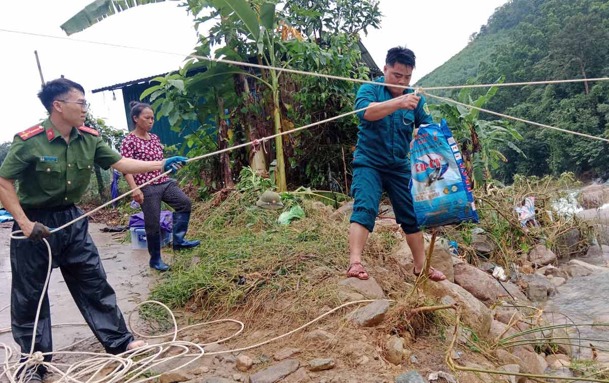 Lực lượng vũ trang hỗ trợ người dân vận chuyển cá từ ao nuôi qua sông. Ảnh: UBMTTQ xã Quảng Tân