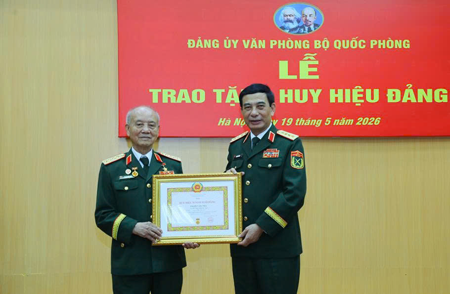 Le général Phan Văn Giang - membre du Bureau politique, secrétaire adjoint de la Commission militaire centrale, vice-Premier ministre du gouvernement, ministre de la Défense nationale a remis l'insigne de 70 ans d'adhésion au Parti au général Phạm Văn Trà. Photo: Ministère de la Défense nationale